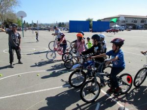 6 children on bikes and wearing helmets in a row