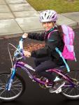 girl on bike with backpack and helmet