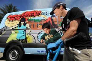 man and young boy with bike in front of van