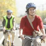 Woman riding bike with helmet and smiling