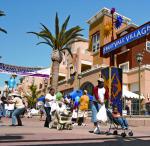 people walking around in a shopping plaza with palm trees