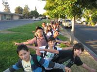 kids lined up on the sidewalk with school backpacks