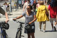 woman walking her bike on a crowded sidewalk