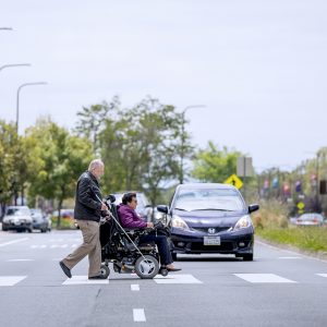 paratransit, person in wheelchair and blind person with cane walking across street