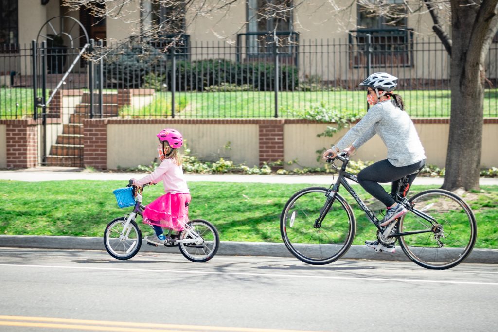 Mother and child cycling with masks